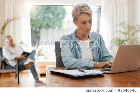 Woman on laptop doing financial budget, taxes or planning monthly finance bank payment at home living room desk. Lady working remote on debt solution, typing on computer and husband reading a book 95040546