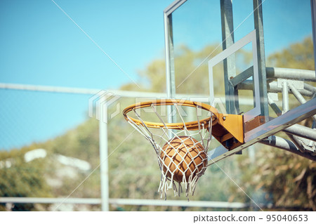 Basketball court, sport and ball or ring net against a blue sky outside. Score and performance during sports, competition and game outdoor. Background of rim, goal and target in competitive mtach 95040653