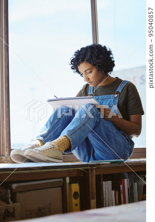 Creative, art and woman drawing by a window and sitting in her artistic studio or workshop. Creativity craft, hobby and professional girl artist sketching an illustration or design in her workspace. Creative, art and woman drawing by a window and sitting in her artistic studio or workshop. Creativity craft, hobby and professional girl artist sketching an illustration or design in her workspace. 95040857