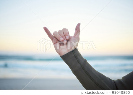 Shaka, surf and sports with the hand sign of a man on the beach for surfing, fitness or exercise in the morning. Workout, training and health with a male surfer outdoor for wellness or cardio Shaka, surf and sports with the hand sign of a man on the beach for surfing, fitness or exercise in the morning. Workout, training and health with a male surfer outdoor for wellness or cardio 95040890