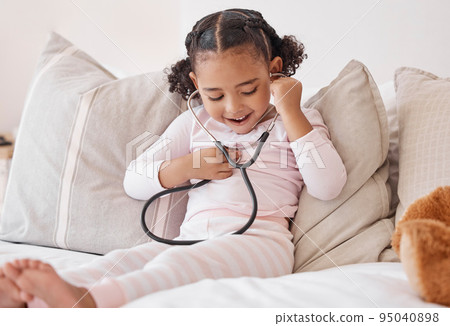 Happy girl, doctor stethoscope and listening to heartbeat sound with excited smile at play learning. Young and curious child with healthcare exam equipment smiling with joy in home bedroom. 95040898