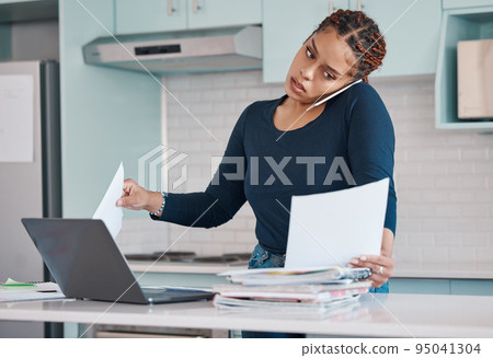 Black business woman working from home in freelance, multitasking paperwork with laptop and mobile audio phone call. Internet technology in kitchen, consulting invoice documents in covid pandemic 95041304