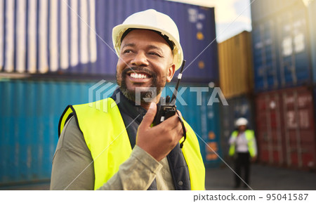 Man in logistics talking on radio, communication in shipping and transportation industry with a smile. Organization of commercial cargo, e-commerce containers and supply chain management of shipyard 95041587
