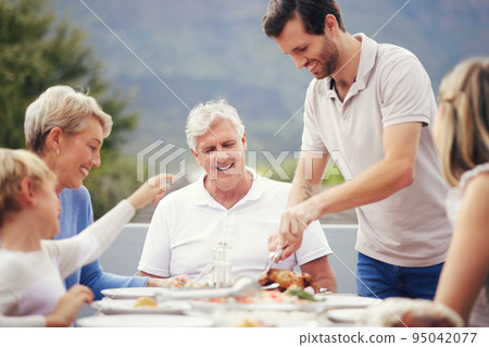 Family eating lunch outdoor garden for holiday celebration, fathers day or thanksgiving turkey food. Happy, care and love people with grandparents and child brunch together in garden to celebrate dad 95042077