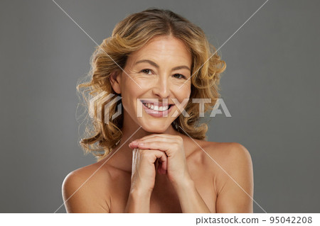 Mature model, skincare and face with beauty, hands and dermatology happy in cosmetics studio. Woman, skin and smile for health, happiness and wellness portrait show healthy body against backdrop 95042208