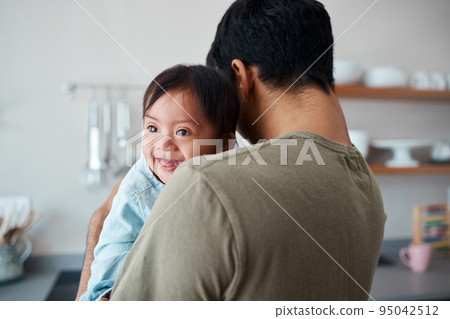 Down syndrome, baby and father bonding in a kitchen, happy and relax in their home together. Disability, development and child care for special needs with loving parent holding and comfort newborn 95042512