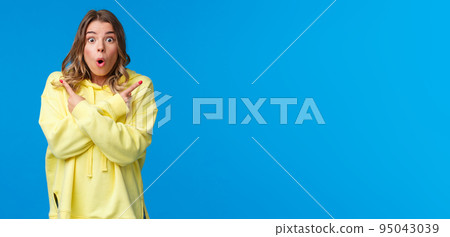 Astonished and excited young blond girl visit awesome place as cant decide what better buy, pointing fingers sideways at left and right product advertisement, look camera ask help with decision Astonished and excited young blond girl visit awesome place as cant decide what better buy, pointing fingers sideways at left and right product advertisement, look camera ask help with decision 95043039