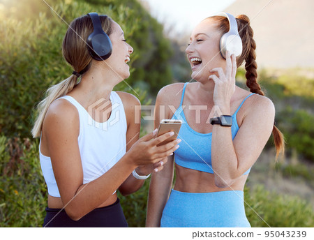 Fitness music, happy nature and friends listening to radio with phone while training in summer, smile for podcast during workout and motivation for gym. Women with funny audio during outdoor exercise Fitness music, happy nature and friends listening to radio with phone while training in summer, smile for podcast during workout and motivation for gym. Women with funny audio during outdoor exercise 95043239