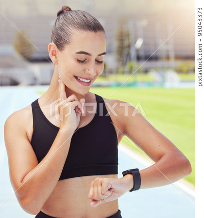 Sport, watch and time with a sports woman training during a workout and checking or tracking her progress. Health, fitness and wellness with a young female athlete timing her performance on a run 95043373