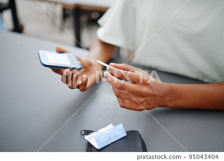 Diabetes, hands and black woman with glucometer on desk checking blood sugar levels. Healthcare, health and student learning how to use glucose meter to test insulin levels for wellness or education 95043404