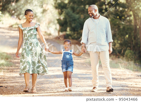 Black family, love and active parents walking with their child through nature for an adventure and outdoor fun. Happy african man and woman with daughter enjoying travel, vacation and leisure walk Black family, love and active parents walking with their child through nature for an adventure and outdoor fun. Happy african man and woman with daughter enjoying travel, vacation and leisure walk 95043466