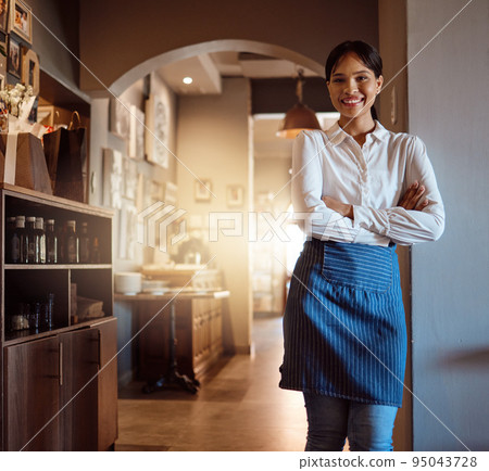 Woman at hospitality restaurant, waitress with a smile and confidence waiting for customers for dinner or lunch service. Portrait of friendly, professional waiting staff in uniform and in clean apron Woman at hospitality restaurant, waitress with a smile and confidence waiting for customers for dinner or lunch service. Portrait of friendly, professional waiting staff in uniform and in clean apron 95043728