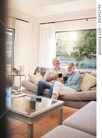 Senior couple with coffee or tea and relax on sofa in their living room happy with retirement, real estate and lifestyle. Elderly people drink on couch or in lounge together while talking of marriage Senior couple with coffee or tea and relax on sofa in their living room happy with retirement, real estate and lifestyle. Elderly people drink on couch or in lounge together while talking of marriage 95043744