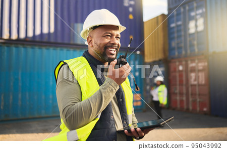 Logistics, radio and a black man in shipping container yard with tablet. Industrial cargo area, happy transport worker talking on walkie talkie in safety gear and working for global freight industry. Logistics, radio and a black man in shipping container yard with tablet. Industrial cargo area, happy transport worker talking on walkie talkie in safety gear and working for global freight industry. 95043992
