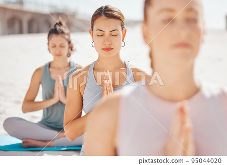 Women friends meditation while training yoga exercise on the beach. Young zen spiritual female athlete workout outdoor. Faith, inner peace, balance and getting healthy focus on a fitness lifestyle Women friends meditation while training yoga exercise on the beach. Young zen spiritual female athlete workout outdoor. Faith, inner peace, balance and getting healthy focus on a fitness lifestyle 95044020