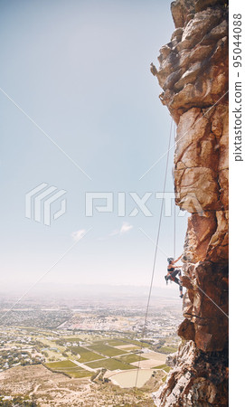 Person rock climbing on a mountain cliff for a challenge in nature with a blue sky and copy space. Woman climber on a rock wall for a fitness workout, exercise and sports training outdoors. Person rock climbing on a mountain cliff for a challenge in nature with a blue sky and copy space. Woman climber on a rock wall for a fitness workout, exercise and sports training outdoors. 95044088