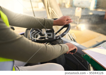 Truck driver man, steering wheel and delivery van cargo, shipping logistics and trade industry supply chain. Hands driving forklift, transport or commercial distribution for industrial construction Truck driver man, steering wheel and delivery van cargo, shipping logistics and trade industry supply chain. Hands driving forklift, transport or commercial distribution for industrial construction 95044126