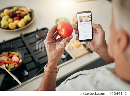 Health, website and phone with man cooking food while reading online with blog, internet or app. Kitchen, network and breakfast with chef with tomato and search recipe for diet, nutrition or lunch Health, website and phone with man cooking food while reading online with blog, internet or app. Kitchen, network and breakfast with chef with tomato and search recipe for diet, nutrition or lunch 95044142
