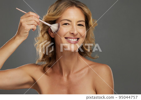 Beauty, makeup and portrait of woman with brush to apply skincare, facial or anti aging cosmetics product. Happy, smile and face of person with makeup brush for wellness routine or natural foundation Beauty, makeup and portrait of woman with brush to apply skincare, facial or anti aging cosmetics product. Happy, smile and face of person with makeup brush for wellness routine or natural foundation 95044757
