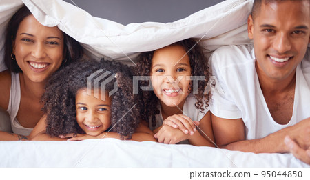Portrait of happy black family bonding on a bed, relax and smile in a bedroom together. Love, blanket and happiness parents enjoying free time with their children, being playful and love in morning 95044850