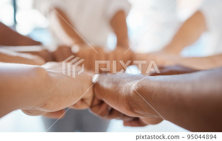 Hands, teamwork and motivation with a team of business people joining their fists in a huddle or circle. Collaboration, goal and target with a group of staff in their office for unity and success 95044894