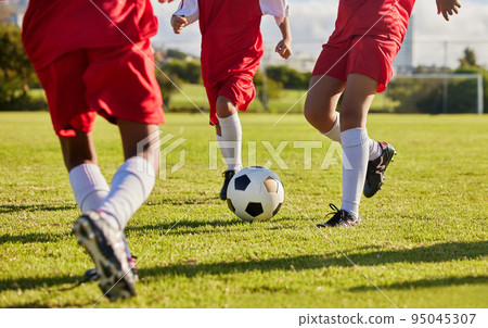 Kids team, soccer or legs with soccer ball in workout, fitness game or exercise on nature park grass, high school stadium or field. Football or sports training with energy in health or girls wellness 95045307
