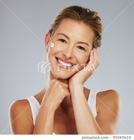 Wellness, beauty and skincare by older woman apply face cream, happy with results treatment. Grooming, hygiene and care for wrinkle skin by portrait of ageing female facial against studio background Wellness, beauty and skincare by older woman apply face cream, happy with results treatment. Grooming, hygiene and care for wrinkle skin by portrait of ageing female facial against studio background 95045619