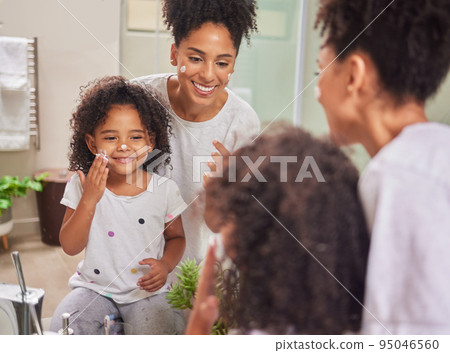 Happy, mother and child with skincare cream in morning routine together for clean and healthy face at home. Smile, fun and beauty of mom in wellness with her baby girl applying lotion to facial skin 95046560