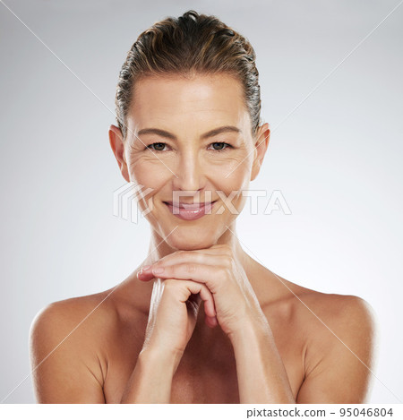 Beauty, skincare and portrait of a mature woman with a smile standing in a studio with a gray background. Senior model with a clean face, wellness and dermatology routine with anti aging healthy skin Beauty, skincare and portrait of a mature woman with a smile standing in a studio with a gray background. Senior model with a clean face, wellness and dermatology routine with anti aging healthy skin 95046804