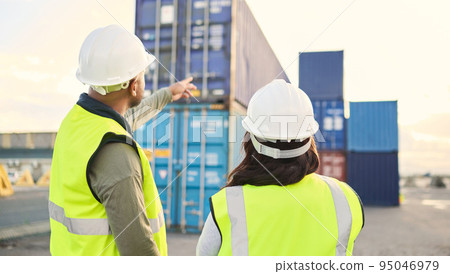 Industrial managers working on a warehouse dock to export stock, containers and packages. Teamwork, collaboration and logistics industry employees discussing shipping at an outdoor cargo freight port Industrial managers working on a warehouse dock to export stock, containers and packages. Teamwork, collaboration and logistics industry employees discussing shipping at an outdoor cargo freight port 95046979