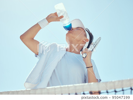 Sport, fitness and tennis man drinking water after workout, training game or health exercise on court. Wellness, sports and drink liquid from bottle after cardio, run or exercising 95047199