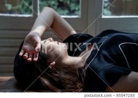 Young woman lying on flooring Young woman lying on flooring 95047288