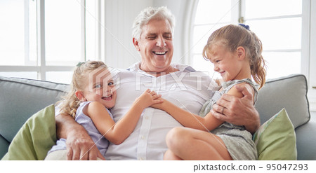 Happy family, retirement and old man playing with children on the sofa bonding, happiness and laughing together. Smile, elderly and grandpa with little girls enjoying quality time on a couch at home Happy family, retirement and old man playing with children on the sofa bonding, happiness and laughing together. Smile, elderly and grandpa with little girls enjoying quality time on a couch at home 95047293