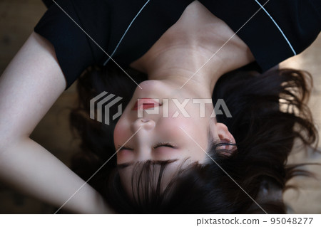 Young woman lying on flooring Young woman lying on flooring 95048277