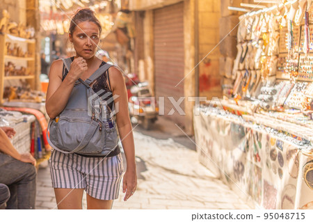 Insecure tourist strolling through a street market in Cairo Insecure tourist strolling through a street market in Cairo 95048715
