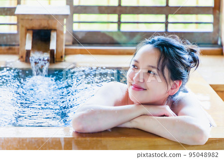 A young woman relaxing in a cypress bath 95048982