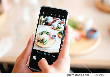 Hands shooting food with a smartphone 95049888
