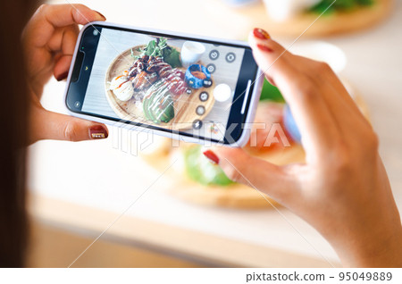 Hands shooting food with a smartphone Hands shooting food with a smartphone 95049889