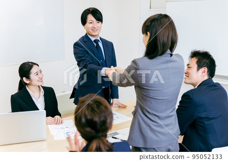 A businessman and a business woman shaking hands after establishing a contract in business negotiations 95052133