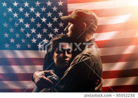 Veterans Day, Memorial Day. A soldier embraces his woman. Couple on the background of the American flag. The concept of the American national holidays and patriotism. 95052238