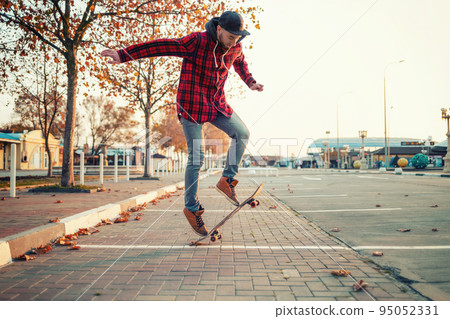 Skateboarding. A man does an Ollie stunt on a skateboard. Jump in the air Skateboarding. A man does an Ollie stunt on a skateboard. Jump in the air 95052331