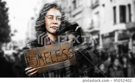 A dirty disheveled woman holds a cardboard sign with the text homeless. Defocused background with street and people. The concept of helping the homeless and vagrants 95052402
