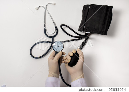 Tonometer in the hands of a doctor. Blood pressure measurement. 95053954