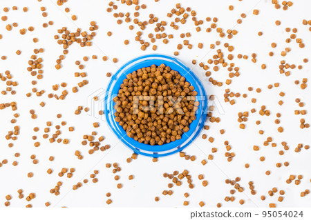 Dry food for kittens and cats in a blue plate on white with space for text. Balanced food, shop for animals Dry food for kittens and cats in a blue plate on white with space for text. Balanced food, shop for animals 95054024