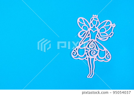 The figure silhouette of the fairy angel on the blue background of the flat lay. Christmas opening in a minimalist style with a place for text. The figure silhouette of the fairy angel on the blue background of the flat lay. Christmas opening in a minimalist style with a place for text. 95054037