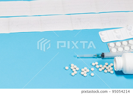 ECG cardiogram and pills for heart and vascular diseases in cardiology. Arrhythmia, myocardial infarction and heart pain and treatment of diseases on a blue. ECG cardiogram and pills for heart and vascular diseases in cardiology. Arrhythmia, myocardial infarction and heart pain and treatment of diseases on a blue. 95054214