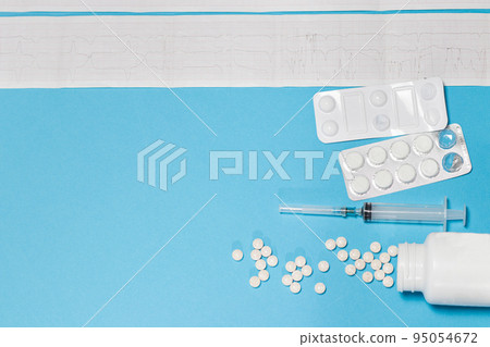 ECG of a patient with myocardial infarction and options for the treatment of cardiovascular diseases - tablets, a syringe on a blue background with a place for text. ECG of a patient with myocardial infarction and options for the treatment of cardiovascular diseases - tablets, a syringe on a blue background with a place for text. 95054672