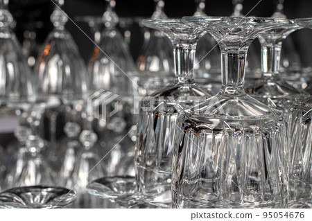 Lots of empty glass glasses for alcohol. Glass upside down. 95054676
