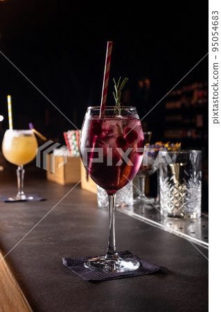 Two alcoholic cocktails pink and yellow on a dark bar. Two alcoholic cocktails pink and yellow on a dark bar. 95054683