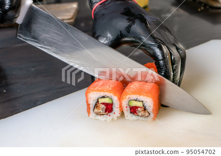 Cut the sushi into pieces. Rolls, cooking. Japanese cuisine. 95054702